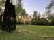 The backyard features a large green lawn and mature trees at 728 W 300 N, Anderson, IN 46011