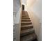 Carpeted stairway with wooden railing and white walls leads to the upper level of the home at 728 W 300 N, Anderson, IN 46011