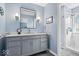 Bathroom with a gray vanity, marble countertop, mosaic backsplash, and a luxurious glass-enclosed shower at 7425 E 300 S, Whitestown, IN 46075