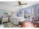 Cozy bedroom with white bedding, a ceiling fan, and a bright window offering views of the landscaped yard at 7425 E 300 S, Whitestown, IN 46075