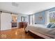 A charming bedroom featuring a sliding barn door leading to an ensuite bathroom and light blue walls at 7425 E 300 S, Whitestown, IN 46075