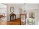 Bright hallway with decorative mirror, unique overhead light, and staircase at 7425 E 300 S, Whitestown, IN 46075