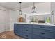 Stylish kitchen island with dark blue cabinetry, quartz countertops, and modern pendant lighting fixtures at 7425 E 300 S, Whitestown, IN 46075