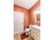 Charming bathroom with marble countertops, white cabinets and an orange accent wall at 8188 Spring Valley Dr, Plainfield, IN 46168