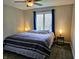 This bedroom offers plush carpeting, a ceiling fan and a bright window with blue curtains at 8188 Spring Valley Dr, Plainfield, IN 46168