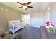 Bedroom with a ceiling fan, gray walls, and carpet flooring, complete with white crib, dresser, and closet at 8188 Spring Valley Dr, Plainfield, IN 46168