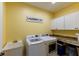 This laundry room features yellow walls, a large utility sink, and washer/dryer at 8188 Spring Valley Dr, Plainfield, IN 46168