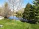 Beautiful backyard pond surrounded by lush greenery and mature trees, creating a serene setting at 8188 Spring Valley Dr, Plainfield, IN 46168
