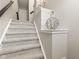 Carpeted staircase featuring neutral tones and decorative accents on the wall at 9014 Ramapo Dr, Fishers, IN 46038
