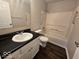 Standard bathroom with sleek black counter on white vanity next to tub and toilet at 9118 Lansburgh Ct, Indianapolis, IN 46234