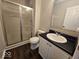 Bright bathroom featuring a vanity with dark countertop and a glass-enclosed shower at 9118 Lansburgh Ct, Indianapolis, IN 46234