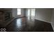 Spacious living room features a brick fireplace and gorgeous dark wood-look flooring throughout at 9118 Lansburgh Ct, Indianapolis, IN 46234