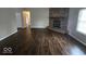 Cozy living room featuring a brick fireplace and wood-look flooring throughout at 9118 Lansburgh Ct, Indianapolis, IN 46234