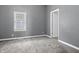 Neutral bedroom with soft carpet, a bright window, and an open doorway at 917 S Grant St, Muncie, IN 47302