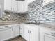 Beautiful kitchen featuring white cabinets, modern hardware, and a unique mosaic backsplash at 917 S Grant St, Muncie, IN 47302