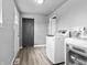 Bright laundry room with modern washer and dryer units and wood-look flooring at 917 S Grant St, Muncie, IN 47302