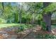 Lush backyard with mature trees, landscaping, and a patio area, perfect for outdoor activities at 1021 N Bolton Ave, Indianapolis, IN 46219