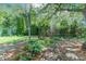Landscaped backyard featuring a rock garden and lush green trees at 1021 N Bolton Ave, Indianapolis, IN 46219