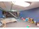 Spacious finished basement featuring carpet, blue walls, and access to stairs at 1021 N Bolton Ave, Indianapolis, IN 46219