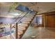 Basement stairs with white railings leading to a finished area with lighting and ample space at 1021 N Bolton Ave, Indianapolis, IN 46219