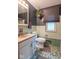 Classic bathroom featuring pastel tile, window with shade, and a hanging plant for a fresh, inviting touch at 1021 N Bolton Ave, Indianapolis, IN 46219