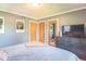 Comfortable bedroom with neutral walls, dresser with television, and multiple doors for easy access at 1021 N Bolton Ave, Indianapolis, IN 46219