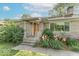 Charming front entrance featuring stone facade and landscaped yard with flowers at 1021 N Bolton Ave, Indianapolis, IN 46219