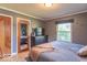 Comfortable main bedroom with hardwood floors, a large window, and a neutral color scheme at 1021 N Bolton Ave, Indianapolis, IN 46219