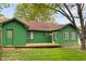 Green home features a deck and lush backyard with mature trees and green lawn at 11 Woodacre Dr, Carmel, IN 46032