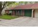 Charming single-story brick home with a well-maintained lawn, red roof, and green trim at 11 Woodacre Dr, Carmel, IN 46032