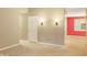 Open hallway featuring neutral carpet, wall sconces, and painted accent wall at the end at 11 Woodacre Dr, Carmel, IN 46032