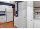 Kitchen with white cabinets, blue countertops, stainless steel refrigerator, and laundry access at 11 Woodacre Dr, Carmel, IN 46032
