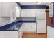 Bright kitchen features white cabinets, stainless steel sink, and blue countertops, offering ample storage at 11 Woodacre Dr, Carmel, IN 46032