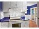 Bright kitchen with white cabinetry, blue countertops, and a white range oven at 11 Woodacre Dr, Carmel, IN 46032