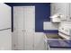 Efficient kitchen with white appliances, cabinets, blue countertops, and ample storage space at 11 Woodacre Dr, Carmel, IN 46032
