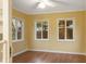 Bright room with wood flooring, three windows offering natural light and backyard views at 11 Woodacre Dr, Carmel, IN 46032