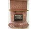 Close-up of a brick fireplace with a wooden mantle and glass-door firebox at 1102 Branifield Ct, Franklin, IN 46131