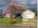 Charming home with a lush green lawn and beautiful flowering tree in the front yard at 1102 Branifield Ct, Franklin, IN 46131