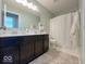 Well-lit bathroom featuring double sinks, modern fixtures, and a shower with a curtain at 1115 Freshwater Ln, Cicero, IN 46034