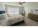 Bright bedroom with a ceiling fan, a large window, and a dresser with decor at 1115 Freshwater Ln, Cicero, IN 46034