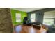 Bedroom with hardwood flooring, large windows, and bright green accent wall at 1126 Kings Ct, Indianapolis, IN 46260