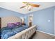 Bright bedroom features blue walls, carpet, ceiling fan, and large bed with furniture at 1127 Alydar Cir, Indianapolis, IN 46217