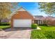 Charming brick home featuring an attached two-car garage and a well-manicured lawn with flowering trees at 1127 Alydar Cir, Indianapolis, IN 46217
