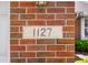 Close-up of the house number '1127' on a brick pillar with partial view of the home at 1127 Alydar Cir, Indianapolis, IN 46217