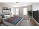 Cozy bedroom features a bed with a padded headboard, complemented by a leafy green plant and modern decor at 11592 Saltford Ln, Fishers, IN 46037
