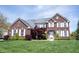 Beautiful two-story brick home with a manicured lawn and lush landscaping at 11592 Saltford Ln, Fishers, IN 46037