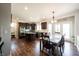 Eat-in kitchen features an island, stainless steel appliances, dark cabinets, and hardwood flooring at 11592 Saltford Ln, Fishers, IN 46037