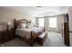 Main bedroom featuring a tray ceiling, carpet floors, and a decorative bed frame at 11592 Saltford Ln, Fishers, IN 46037