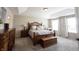 Main bedroom featuring a tray ceiling, carpet floors, and a decorative bed frame at 11592 Saltford Ln, Fishers, IN 46037