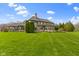 A well-manicured lawn and elegant architecture highlight the beauty of this home's backyard at 12010 Landover Ln, Fishers, IN 46037